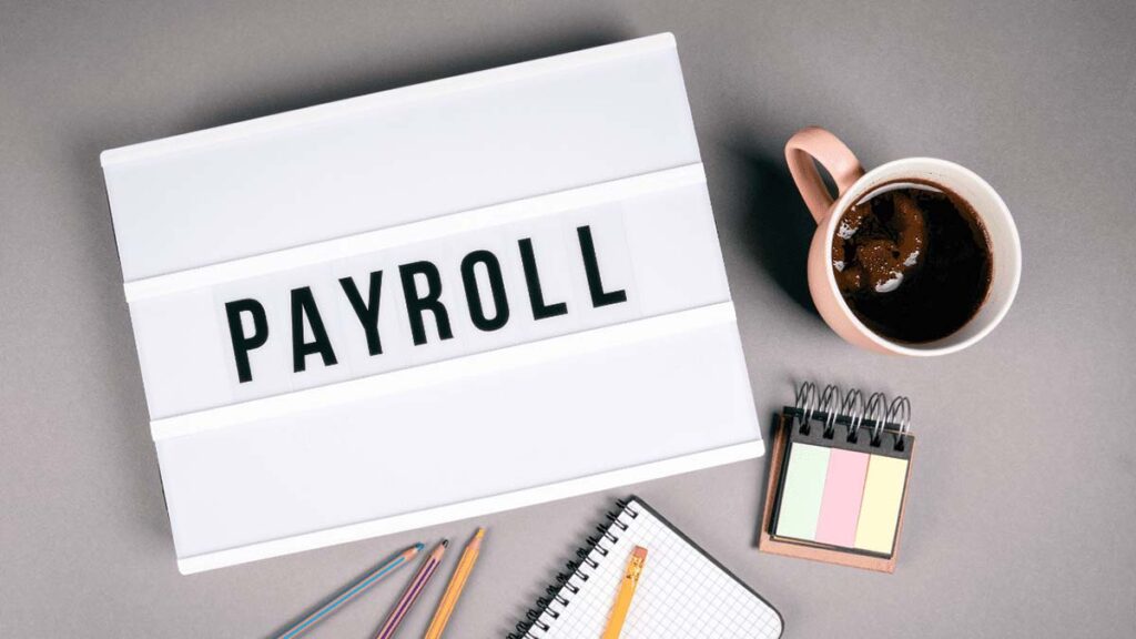 a cup of coffee and one text book payroll image